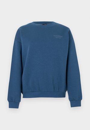 Sweat-shirt bleu en tissu doux, avec un col rond, des manches longues, des poignets côtelés et un petit motif imprimé sur la poitrine.
