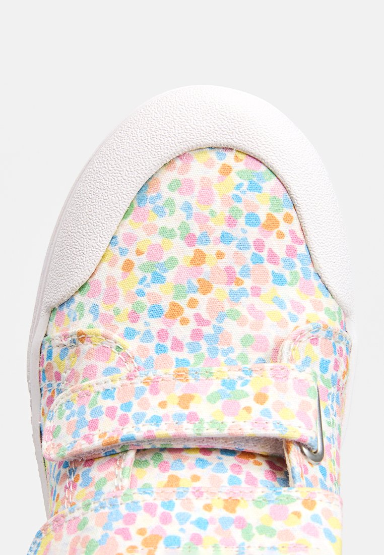Bunte Stoffturnschuhe mit einem gesprenkelten Muster in Pastellfarben auf einem Canvas-Obermaterial, mit einer weißen strukturierten Gummizunge und verstellbarem Riemen.