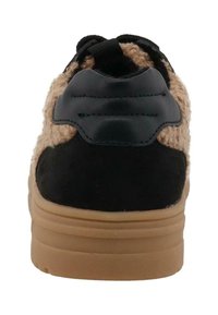 Sneaker met een zwarte leren bovenkant, tan kleurige fuzzy textuur aan de zijkanten en een bruine rubberen zool. Licht verhoogde hak met gestikte accenten.