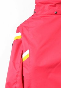 Růžová nepromokavá bunda s vysokým límcem, zdobená bílými a žlutými diagonálními pruhy na rameni. Hladká textura a cvokové knoflíky.