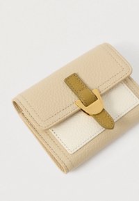 Vä beige texturerad läderplånbok med ett guldspänne och en olivgrön rem mot en vit bakgrund.