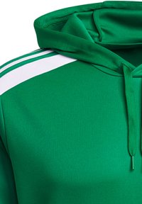 Sweat à capuche vert en tissu lisse avec une capuche à cordon, présentant des rayures blanches sur les épaules et une surface texturée.