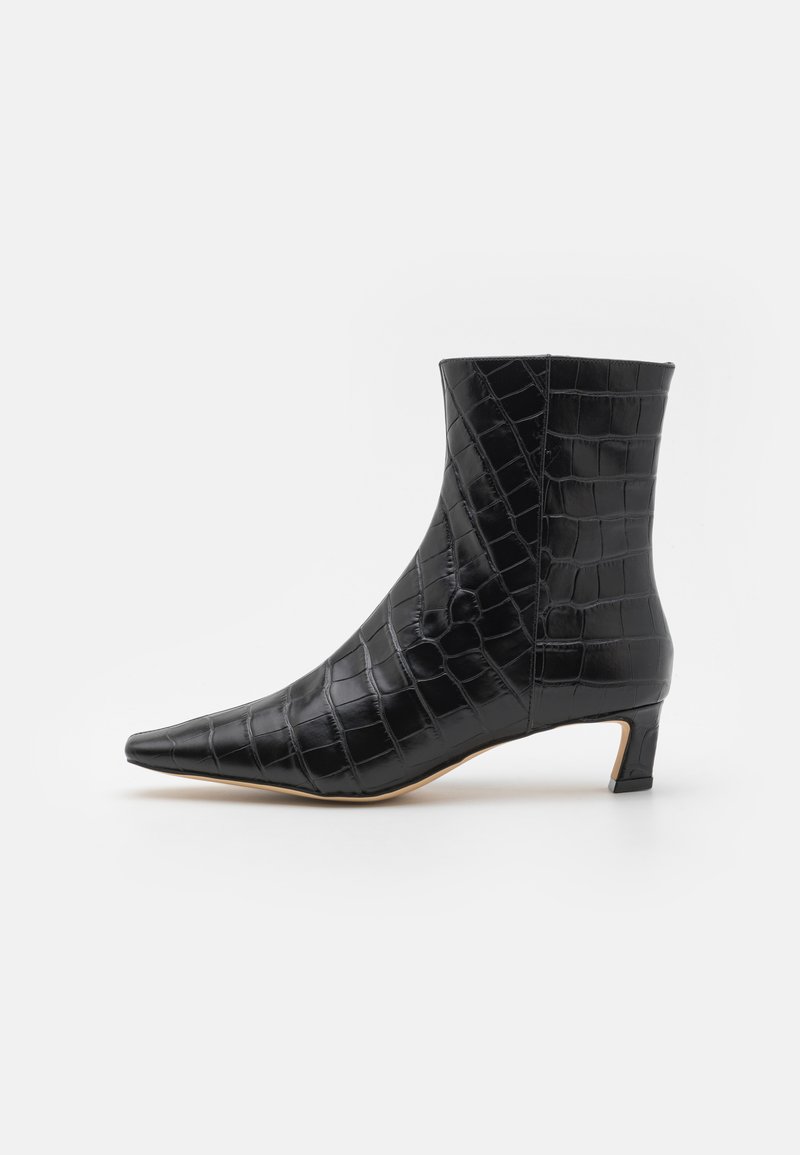 Bottine noire à bout pointu, fabriquée en matériau verni à motif crocodile. Dispose d'un petit talon bloc et d'une silhouette épurée.