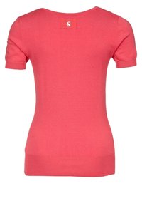 Suéter de manga corta color coral con un diseño ajustado. Textura suave, dobladillo y puños de manga acanalados. Etiqueta visible en la parte posterior del cuello.