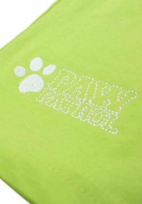 Tissu vert citron affichant "PAW PATROL" en lettres blanches brodées, accompagné d'un motif de patte blanche. Texture lisse, style décontracté.