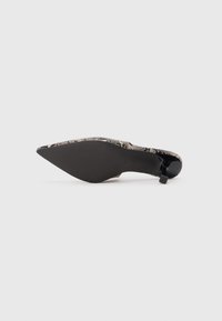 Sīku purngalu augstpapēžu kurpes ar melnu un zeltītu austu virsu, elegantu stiletto papēdi un gludu melnu zoli. Minimālistisks loku akcents papēdī.