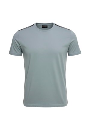 T-shirt azzurro chiaro a maniche corte con scollo rotondo e nastro nero con marchio che corre lungo la parte superiore di entrambe le spalle.