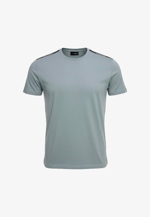 T-shirt azzurro chiaro a maniche corte con scollo rotondo e nastro nero con marchio che corre lungo la parte superiore di entrambe le spalle.