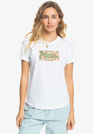 T-shirt en coton blanc avec un graphique floral rectangulaire vert portant le mot "ROXY" au centre. Manches courtes et coupe décontractée.