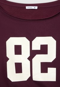T-shirt bordeaux con grandi numeri bianchi stampati "82" sulla parte anteriore, texture morbida, scollatura rotonda e etichetta Terranova. Taglia S.