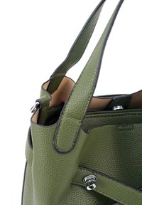 Groene leren handtas met een gepolijste textuur, met contrasterende zwarte accenten, twee stevige handvatten en een met rits afsluitbaar binnenvak.