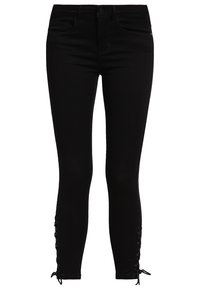 Jeans negros ajustados con una textura suave, que presentan detalles decorativos de lazo en el tobillo y un estilo tradicional de cinco bolsillos.