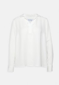 Blusa bianca a maniche lunghe con scollatura a V e colletto, realizzata in tessuto morbido. Presenta polsini con bottone e orlo dritto, design minimalista.