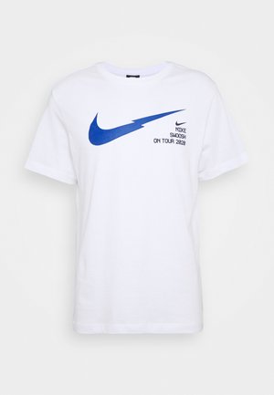 T-shirt en coton blanc avec un logo Swoosh Nike bleu et le texte "Nike Swoosh On Tour 2020" imprimé en noir à l'avant. Manches courtes.