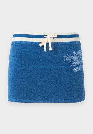 Μπλε φούστα από πετσέτα με λευκή ριγέ μέση, κορδόνι μπροστά και διακριτικό λουλουδάτο σχέδιο στη δεξιά πλευρά.