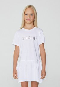 Weißes Baumwollkleid mit kurzen Ärmeln, gerafftem Bund und gerüschtem Saum. Verfügt über einen metallischen "SPARKLING" Schriftzug in schillernden Farben.
