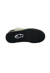 Zapatilla con una suela de goma negra texturizada, parte superior de malla verde y detalles en blanco. Presenta un logotipo prominente en la suela.