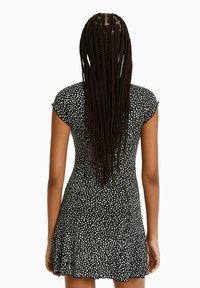 Musta mekko valkoisella kukkakuviolla, lyhyet hihat, vartaloa myötäilevä muotoilu ja liehukehä. Sujuva kangas, jossa on kevyt rakenne.