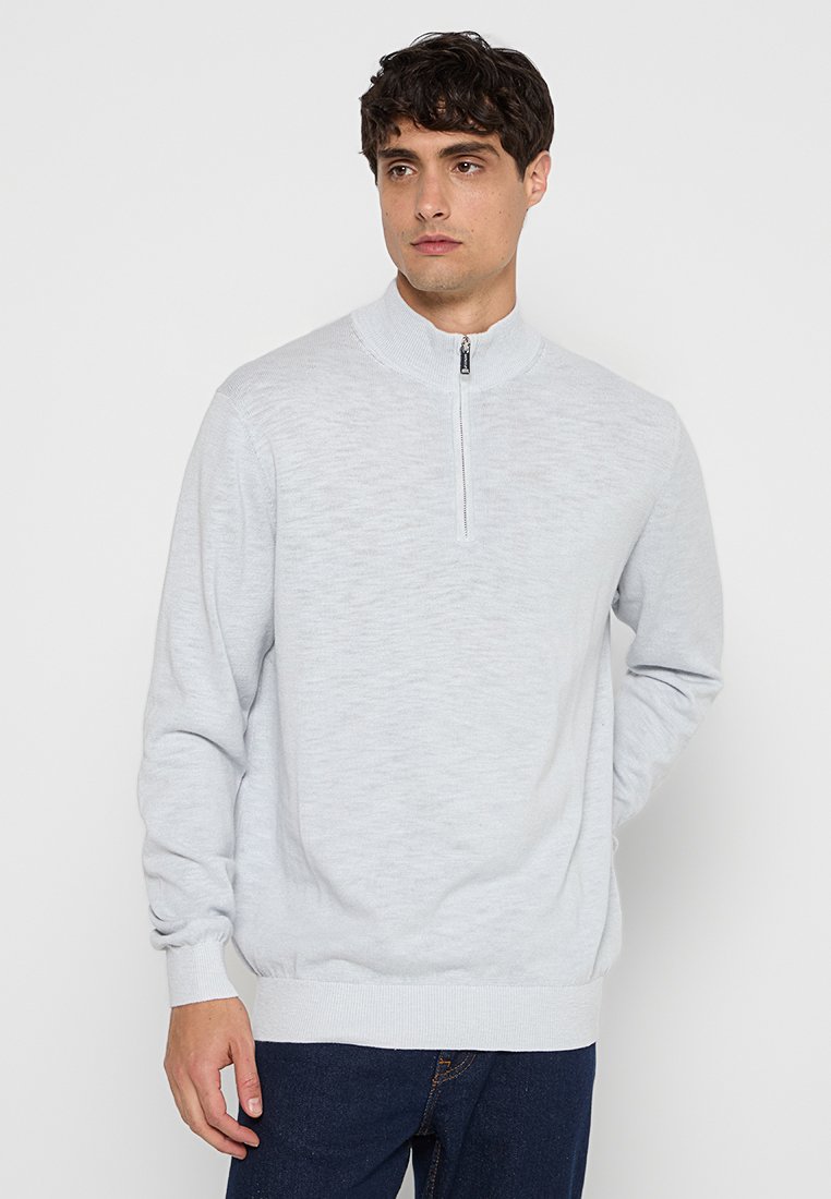 Helles grauer Reißverschluss-Pullover aus weichem Strickmaterial. Verfügt über einen hohen Kragen sowie gerippte Säume und Bündchen. Einfaches, lässiges Design.