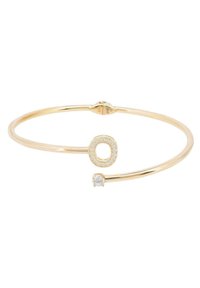 Gold-tone bangle bracelet featuring a circular accent with micro-paving of small stones and a single prominent clear stone detail.