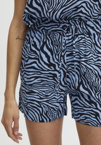 Pantaloni corti a zebra blu e neri con vita elasticizzata e cordoncino. Realizzati in tessuto morbido, presentano una vestibilità ampia e tasche laterali.