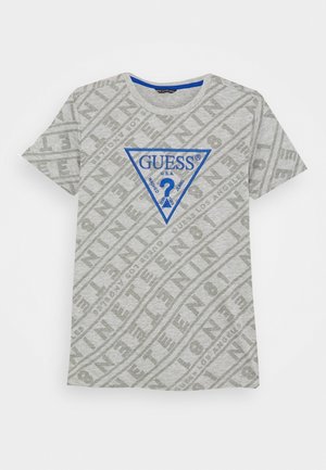 T-shirt gris clair à manches courtes avec motif de texte en diagonale et triangle du logo Guess bleu avec un point d'interrogation sur la poitrine.