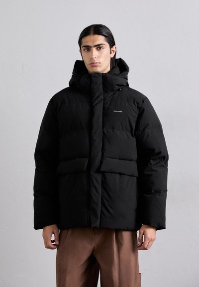 Schwarze Pufferjacke mit hohem Kragen und angeschAttached Kapuze. Mit gequilteten Einsätzen, einem zentralen Reißverschluss und zwei großen Fronttaschen.