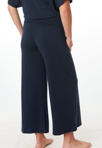 Marineblauwe wijde broek van zachte, rekbare stof. Beschikt over een comfortabele tailleband en een soepele, vloeiende uitstraling.