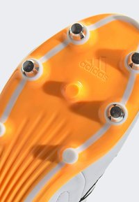 Soccer cleat sole in vibrant orange with black studs and white accents. Features branding and textured ridges for traction.