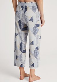 Katoenen pyjamabroek met een patchworkontwerp van blauwe, gele en witte driehoeken. Elastische tailleband, cropped lengte en lichtgewicht stof.