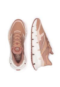 Bežecké topánky Reebok v odtieňoch ružovej a béžovej, so sieťovinovým zvrškom, textúrovaným dizajnom a kontrastnou bielou podrážkou s výrazným vzorom.