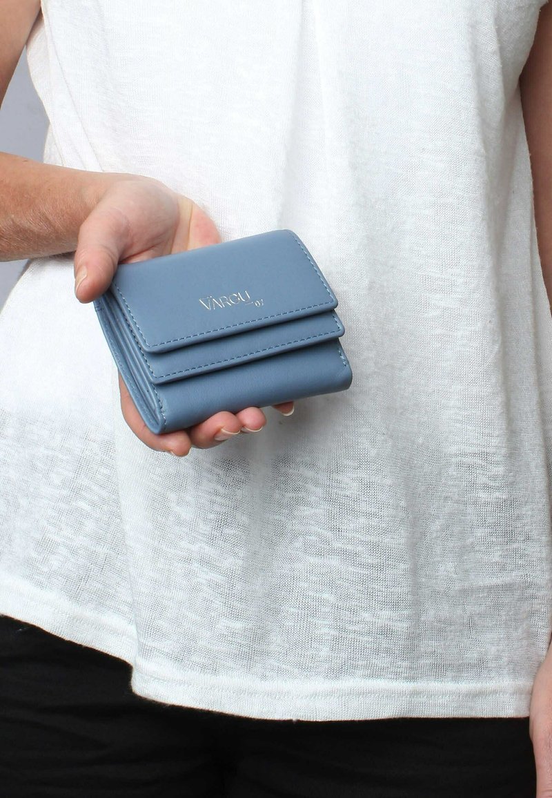 Blue leather wallet with two stacked compartments, featuring a smooth texture and embossed brand logo on the front. Compact design held in a hand.