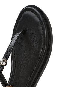 Sandalo in cuoio nero con soletta morbida, cuciture sottili e una decorazione di strass sul cinturino. Design regolabile.