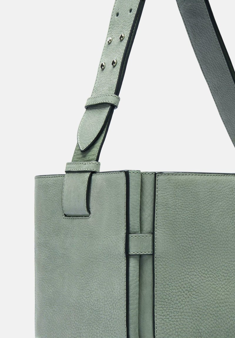 Lichtgroene leren handtas met een gestructureerd oppervlak, accentstiksels, een verstelbare schouderband en details in zilverkleurige hardware.