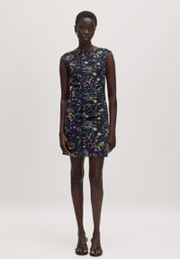 Blumenmuster-Kleid in dunklem Marineblau, mit taillierter Silhouette, ärmellosem Design und gerafften Details. Kombiniert mit schwarzen Sandalen.