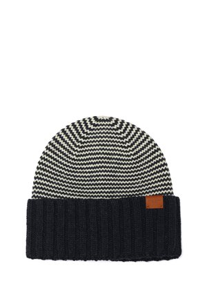 Bonnet en maille avec motif zigzag noir et blanc et revers noir uni plié avec une petite étiquette de marque marron.