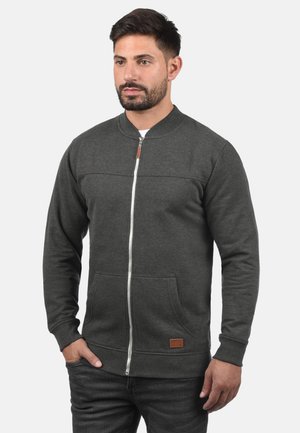 Grå zip-up sweatshirt med ribbede manchetter og nederste kant, med en glat tekstur, to frontlommer og et lille logomærke på den nederste front.