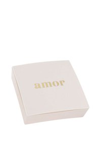 Pequeña caja de joyería blanca en forma de cuadrado con el texto dorado "amor" centrado en la tapa sobre un fondo blanco.