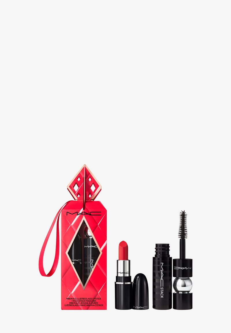 Rode verpakking met een diamantvorm en gouden accenten bevat een rode lippenstift en zwarte mascara. De lippenstift heeft een traditionele kogelvorm.