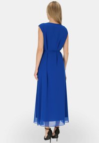 Długa, zwiewna niebieska sukienka z zaokrąglonym dekoltem i krótkimi rękawami typu cap. Tkanina wydaje się lekka i prześwitująca, z paskiem w talii i długością do kostek.
