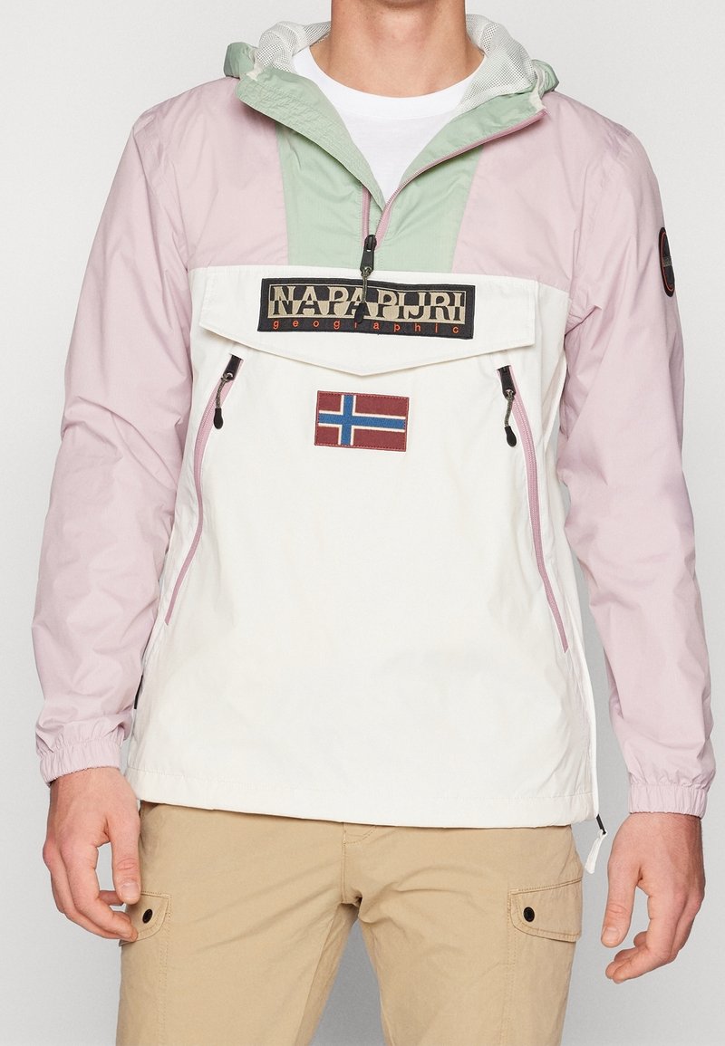 Färgglad anorak i rosa, mintgrön och vitt, med en känguruficka, logopatch och dragkedjefickor på sidorna. Tillverkad av lättviktig tyg.