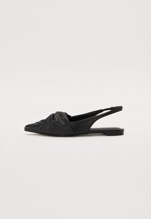Black leather slingback flats featuring a pointed toe, knotted detail at the front, and a flat sole with minimal decorative accents.