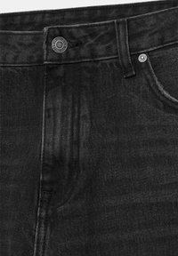 Gros plan sur un jean en denim noir montrant le bouton, la boucle de ceinture, le rivet de la petite poche et les détails de la couture de la poche avant.