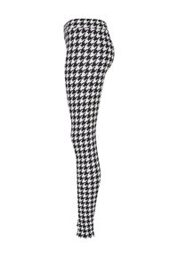 Leggings à motif pied de poule noir et blanc, en tissu extensible, coupe ajustée, taille haute, texture lisse, design de jambe fuselée.