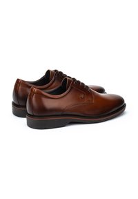 Chaussures de ville en cuir marron avec texture lisse, bout rond, design à cinq œillets et semelle extérieure en caoutchouc noir contrastant.