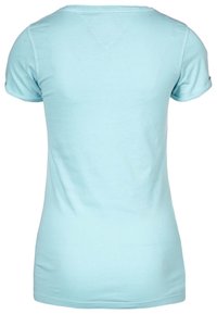 Camiseta ajustada de manga corta azul claro vista desde la parte posterior, con puños enrollados y un detalle en forma de V cosido debajo del cuello.