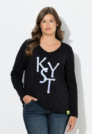 Chemise noire à manches longues avec un grand motif irisé "KYST" sur le devant. Le tissu est lisse, avec une coupe décontractée et un décolleté en V.