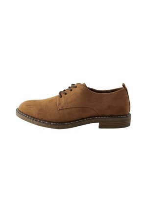 Zapato de ante marrón con cordones y punta redondeada, con costuras en contraste y un tacón bajo. Suela plana con una ligera textura.