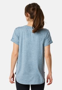 Lichtblauw sportt-shirt met korte mouwen, ronde halslijn en een iets langere achterkant. Zachte, gestructureerde stof lijkt ademend.