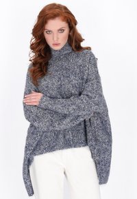 Oversized sweter z golfem w melanżowym niebiesko-szarym dzianinie. Posiada długie rękawy i asymetryczny dół, podkreślając miękką teksturę i przytulny design.